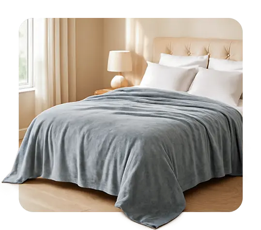 Soft blue blanket neatly laid on a beige bed in a cozy, light-filled bedroom