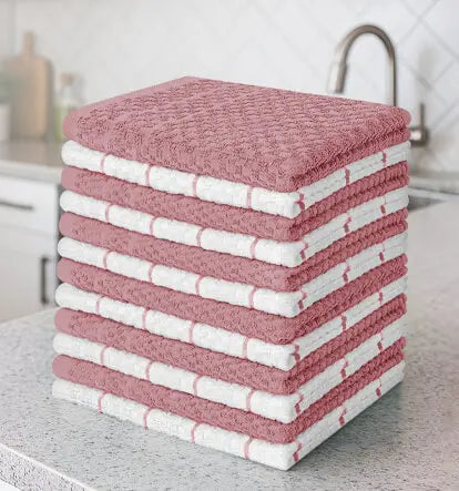 Neatly stacked rose-colored and white kitchen towels on a countertop